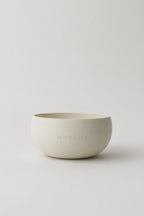 Front view of the NORLUA brass singing bowl in a warm white matte finish