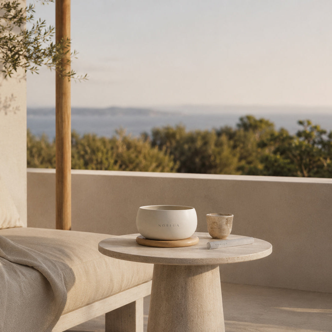 NORLUA singing bowl on a stone table overlooking a coastal landscape