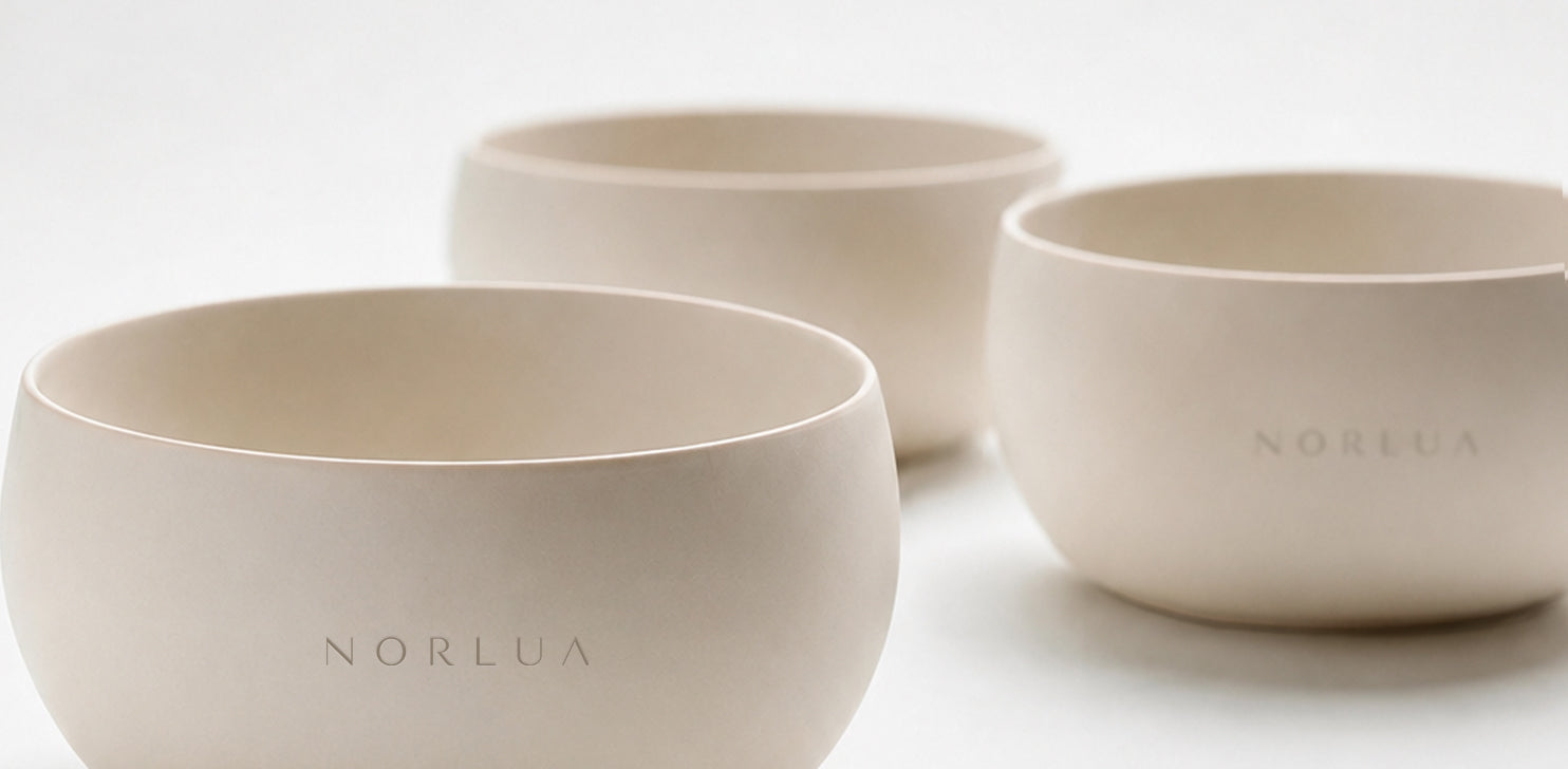 Close-up of multiple NORLUA singing bowls in soft neutral light