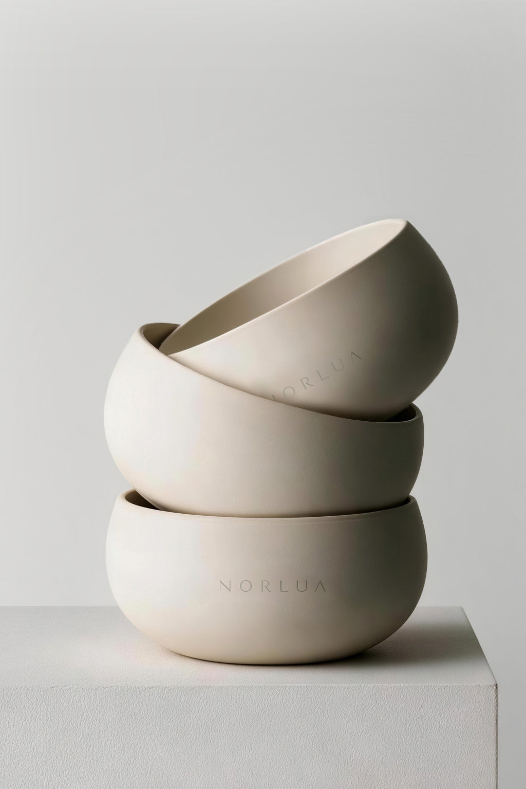 Three NORLUA singing bowls arranged in a sculptural stacked composition